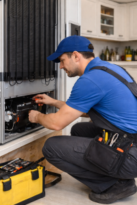 Appliance repair technician working on a refrigerator in a residential kitchen.
